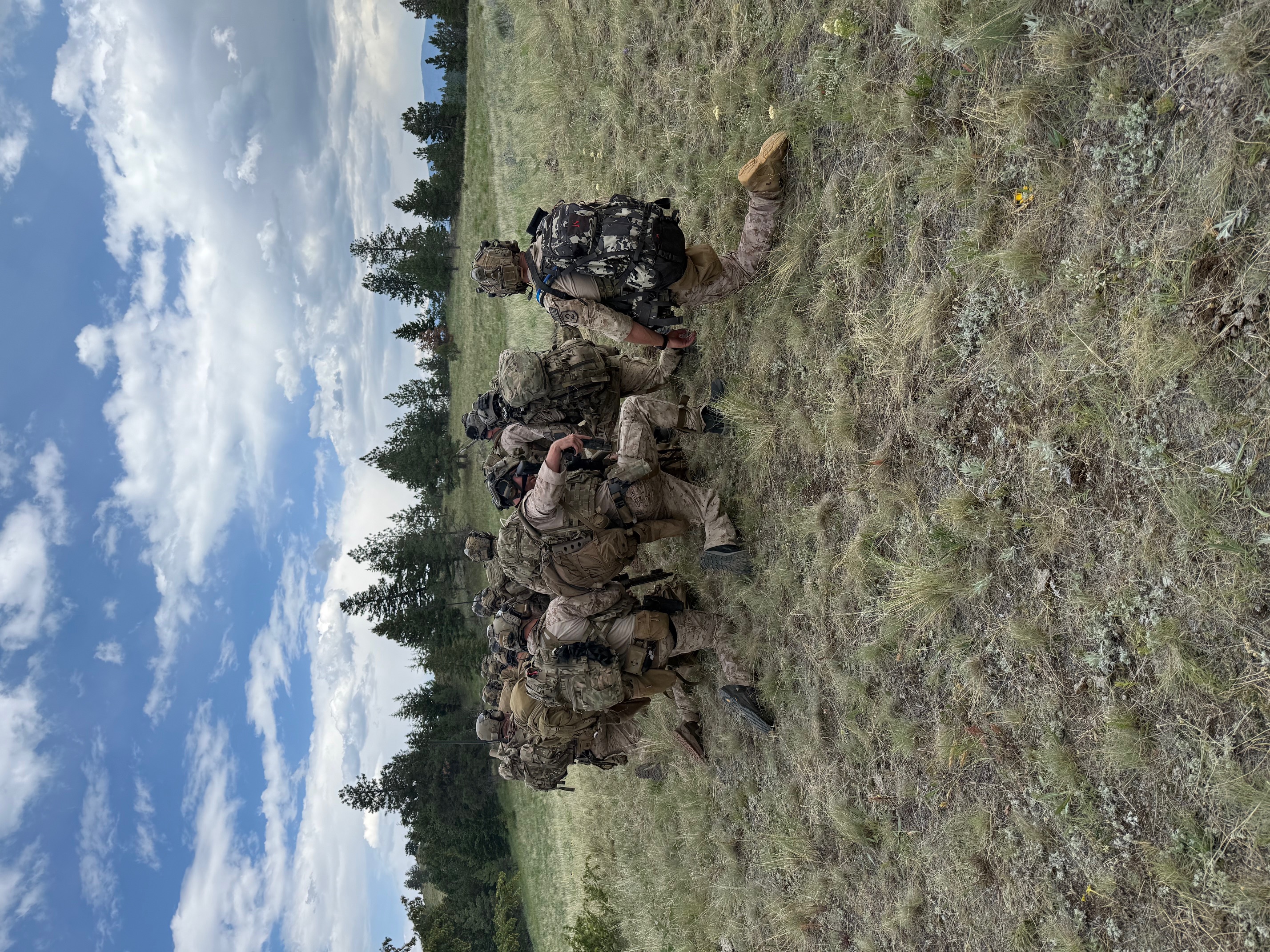 Special forces operators conducting tactical training exercises in Montana field terrain