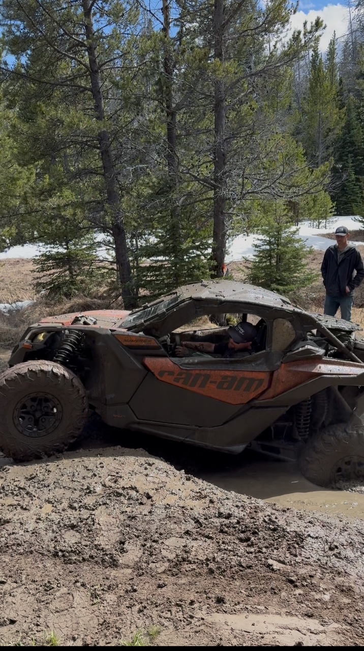 Vehicle navigating deep mud terrain in Montana forest during off-road training