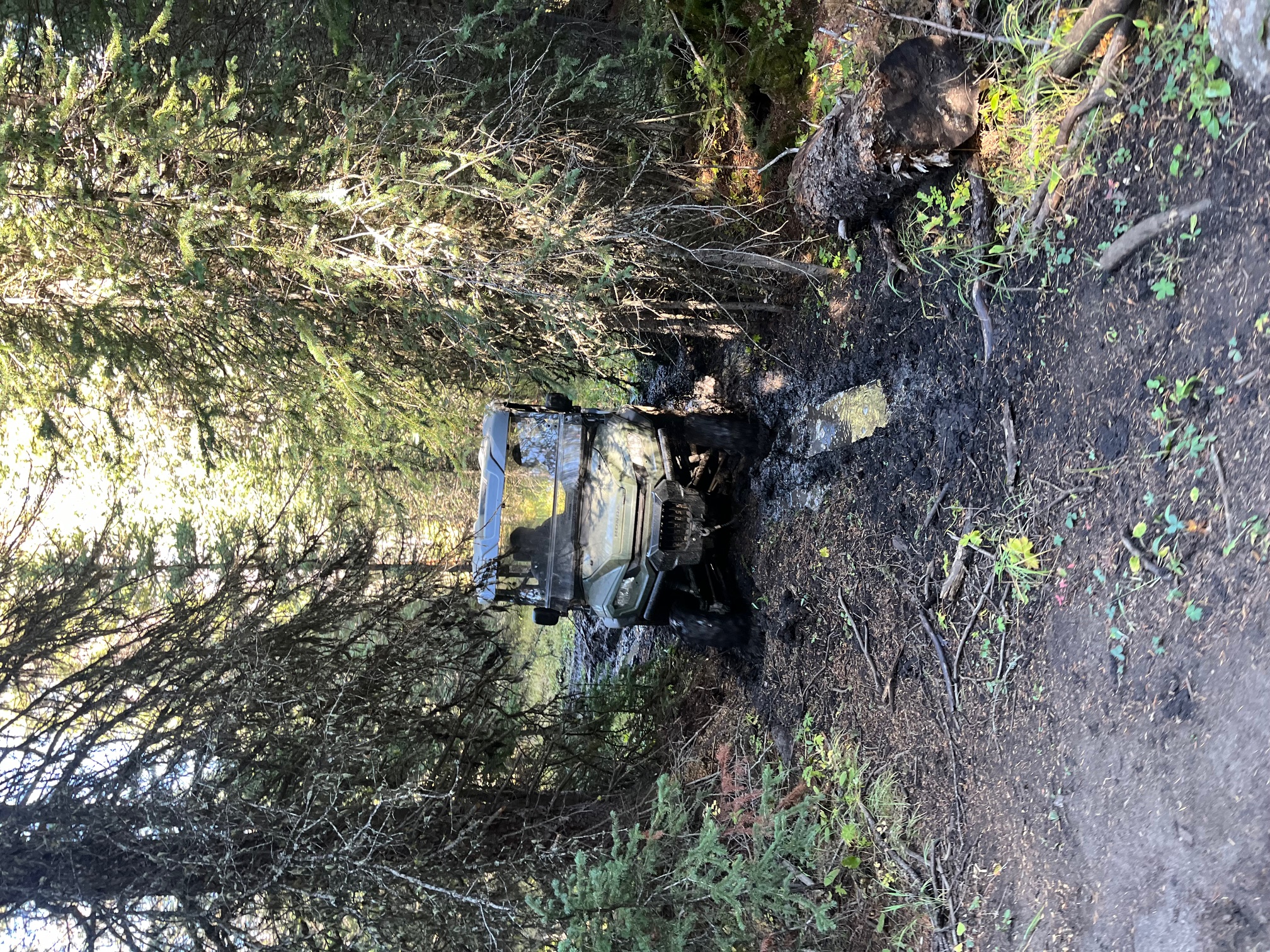 Off-road vehicle crossing a forested creek on the FSG Montana ranch training grounds